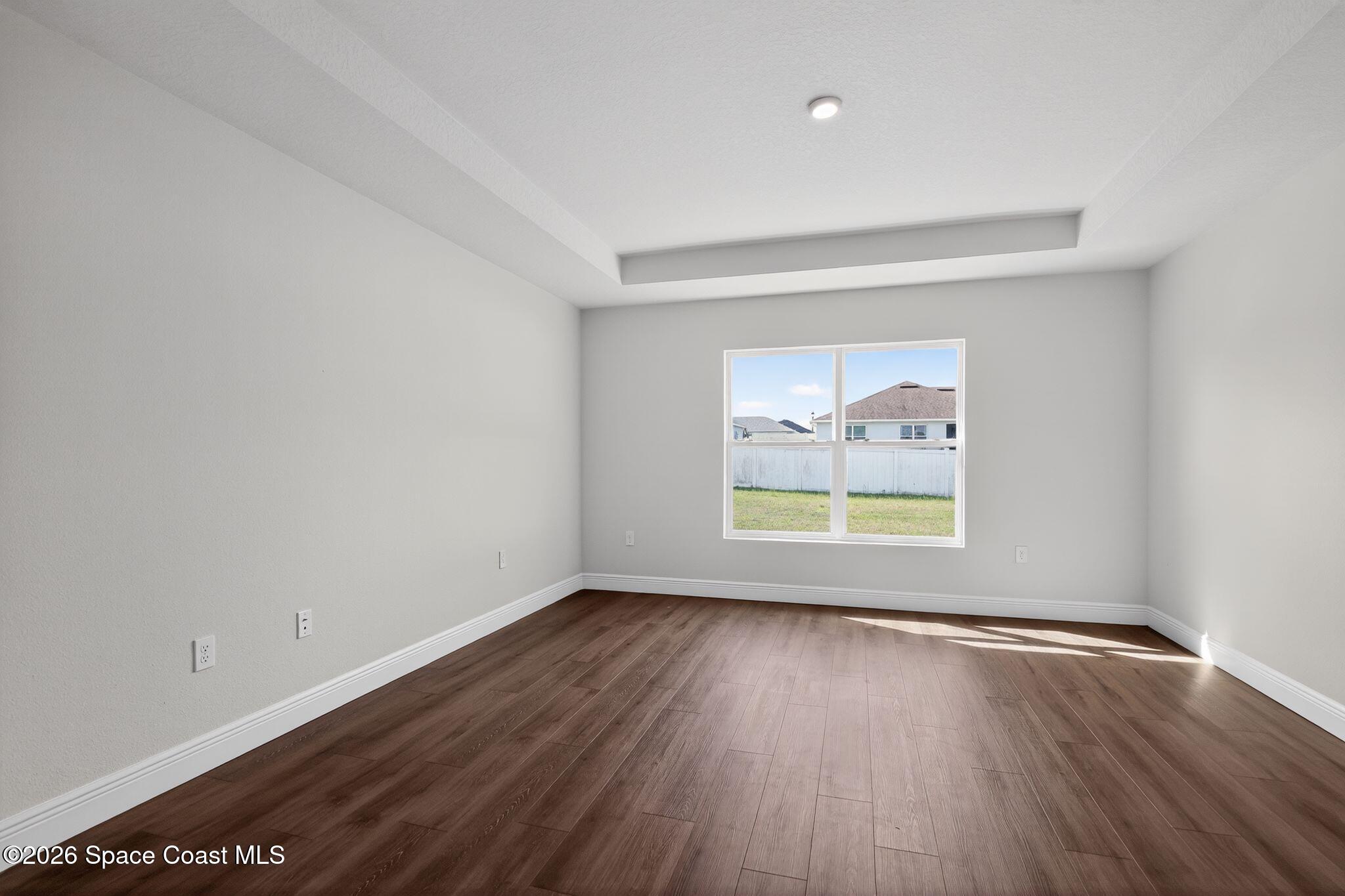 5294 Southeast 91st Street Ocala, FL 34480 - Photo 9 of 15 an empty room with wooden floor and windows