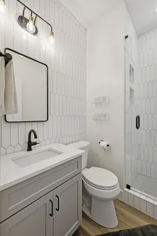 a bathroom with a sink a toilet and shower