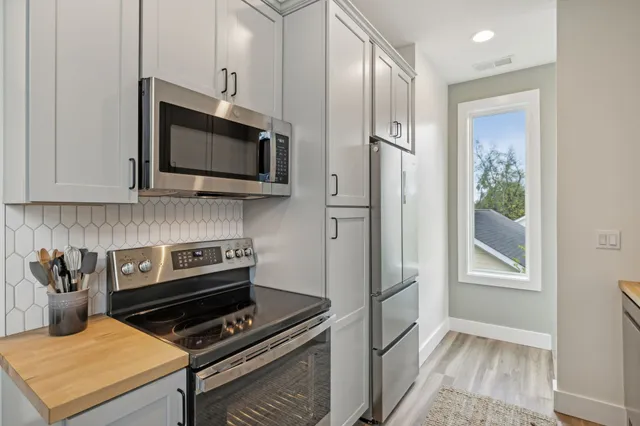 a kitchen with cabinets and steel appliances