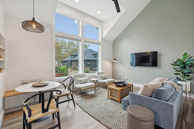a living room with furniture a large window and a flat screen tv