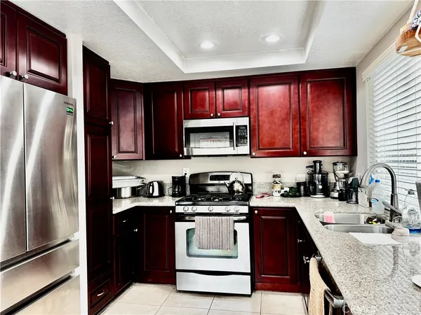 a kitchen with stainless steel appliances granite countertop a refrigerator sink stove and microwave