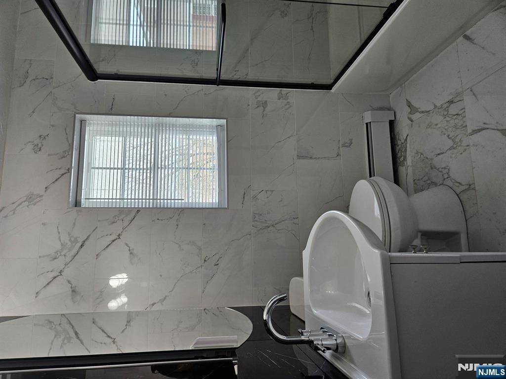 605 Grove Street, Unit F8 Clifton, NJ 07013 - Photo 12 of 15 a bathroom with a sink a toilet and a mirror