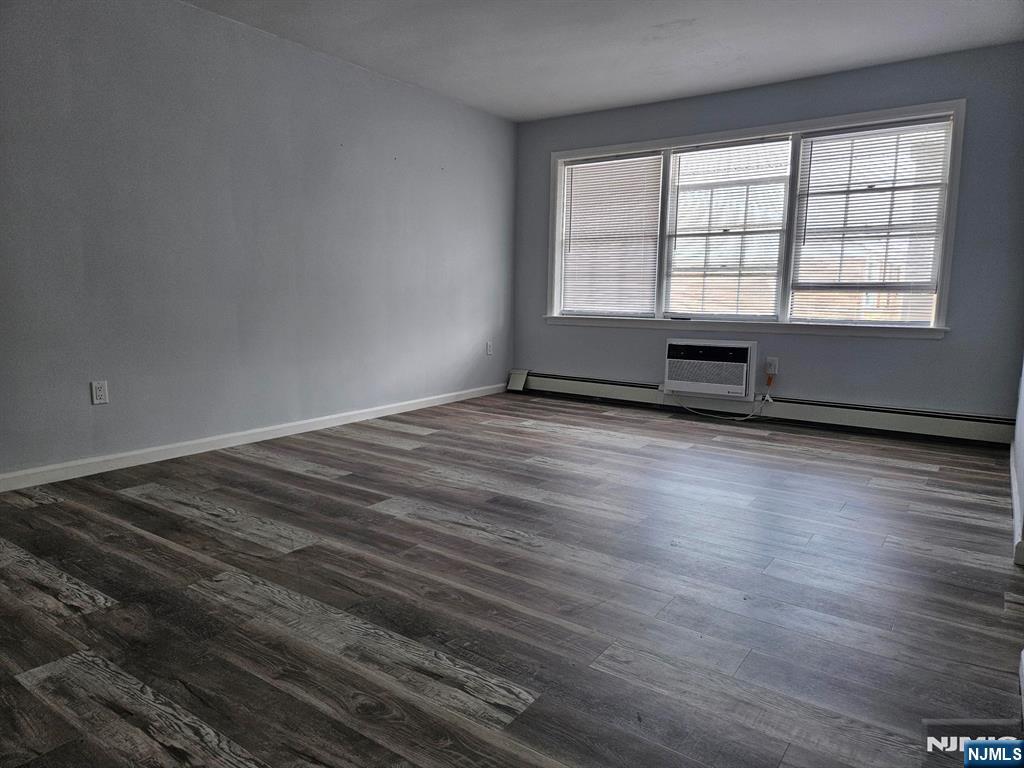 605 Grove Street, Unit F8 Clifton, NJ 07013 - Photo 5 of 15 an empty room with wooden floor and windows