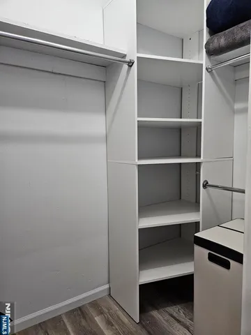 a view of walk in closet with empty racks