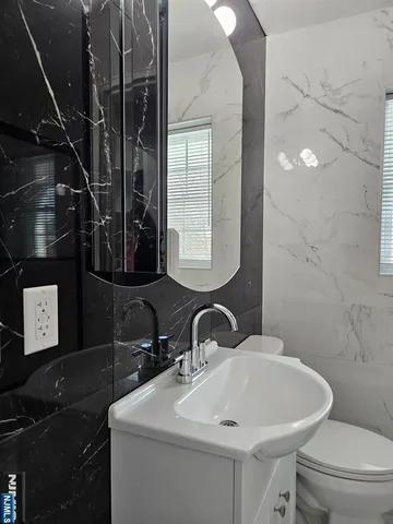 a bathroom with a toilet sink and mirror