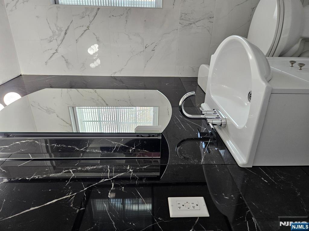 605 Grove Street, Unit F8 Clifton, NJ 07013 - Photo 10 of 15 a bathroom with a toilet sink and mirror