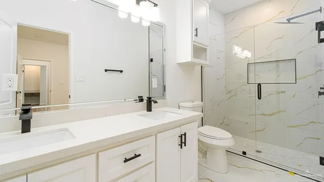 a bathroom with a sink a toilet and shower