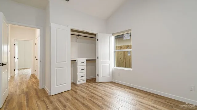 a view of empty room with wooden floor