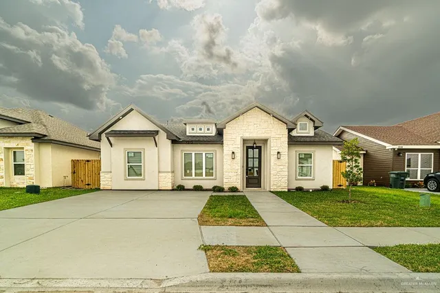a view of a white house with a big yard and large trees