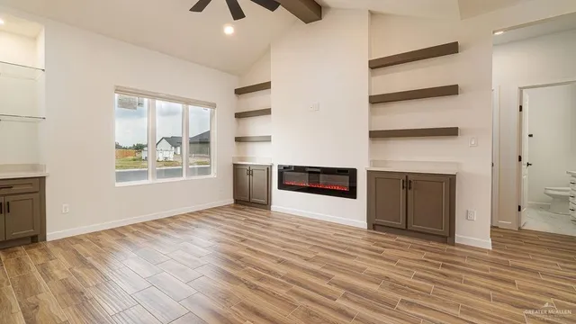 a view of an empty room with a window and fireplace