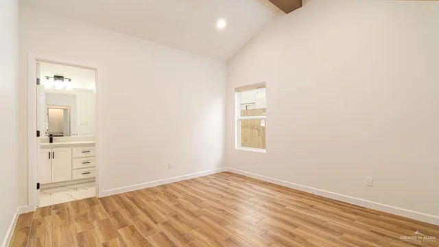 an empty room with a bathroom and mirror