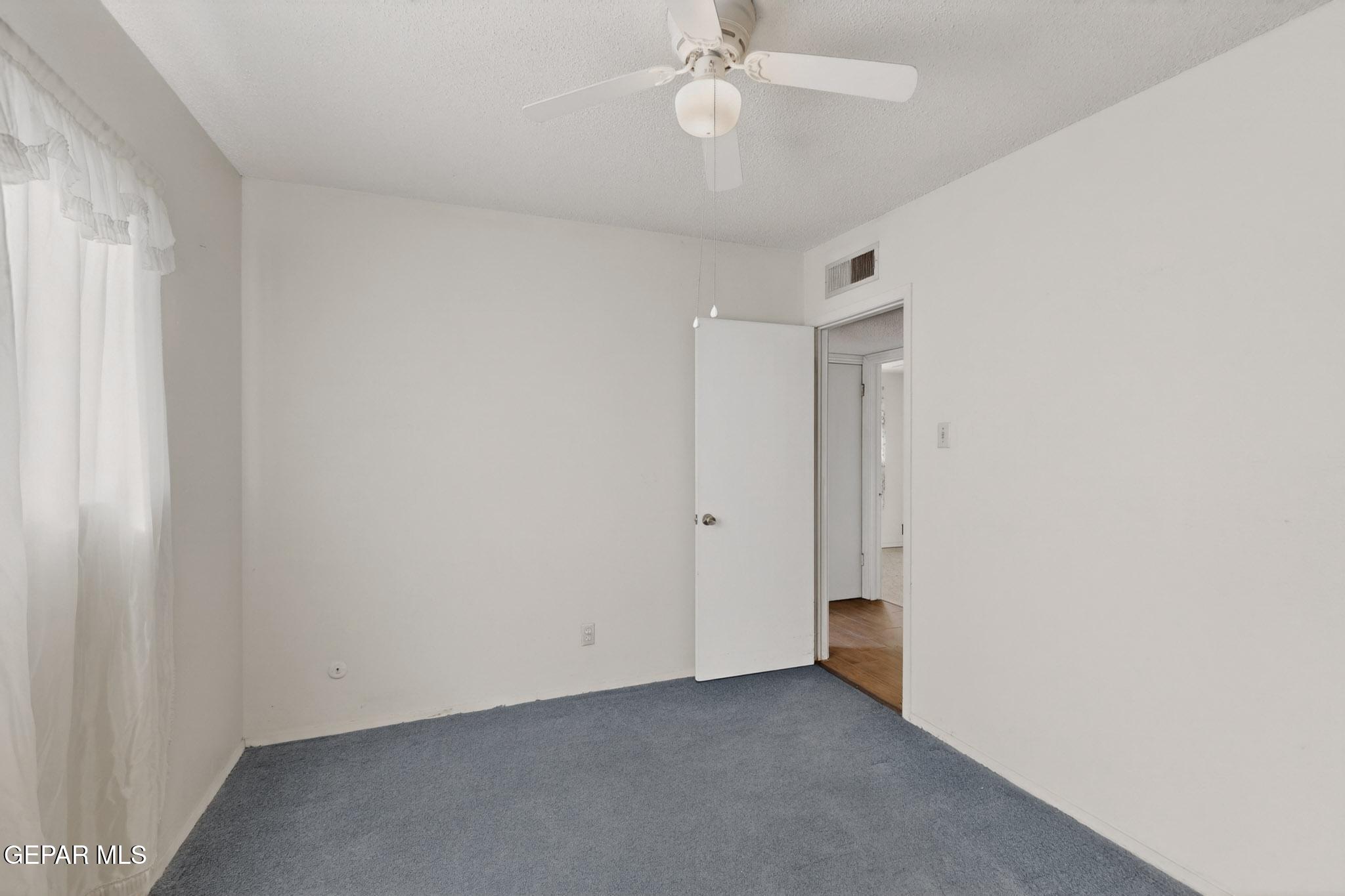917 Marigold Way El Paso, TX 79907 - Photo 16 of 38 an empty room with a ceiling fan and a window