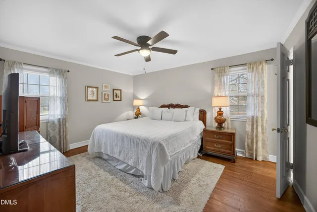 a bedroom with a large bed and a flat tv screen on dresser
