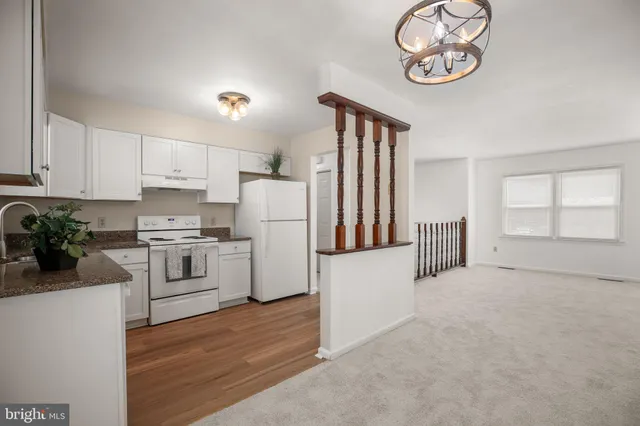 a kitchen with a refrigerator and a stove top oven