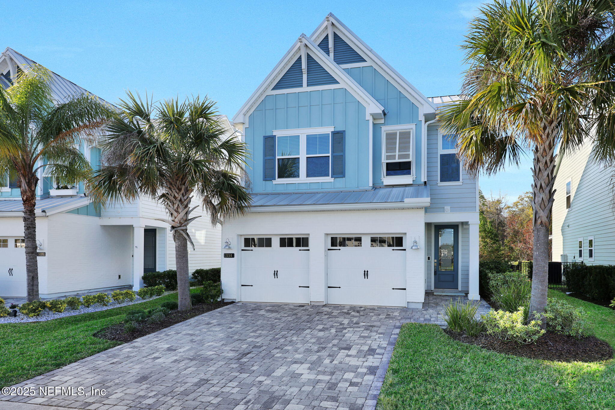 a view of a house with a yard and palm trees