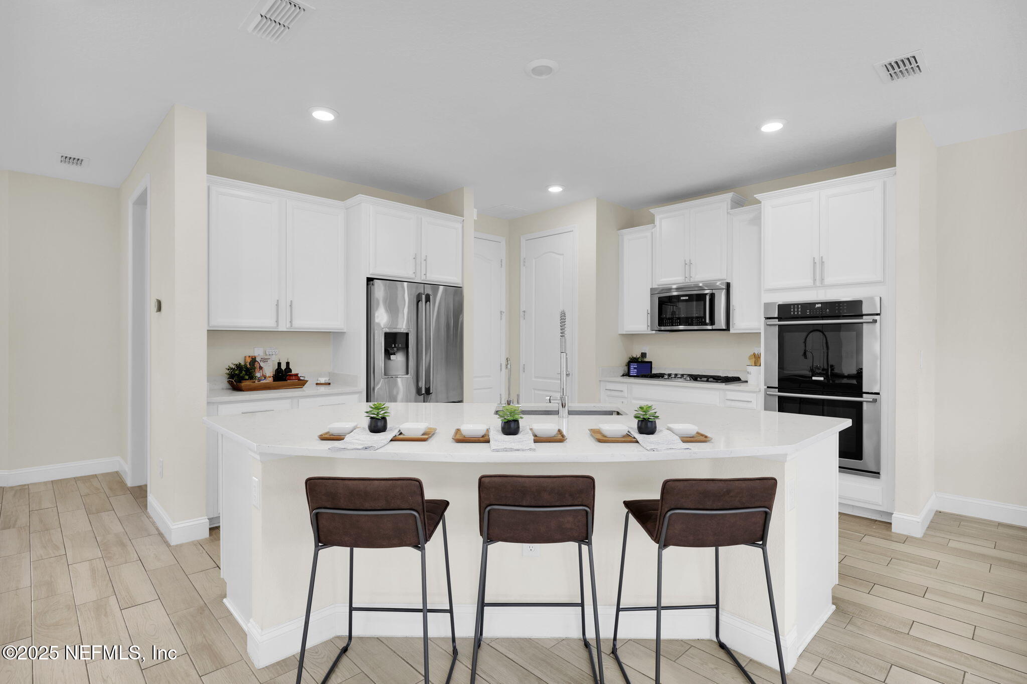 334 Clifton Bay Loop St. Johns, FL 32259 - Photo 8 of 60 a kitchen with stainless steel appliances kitchen island granite countertop a dining table chairs refrigerator and sink