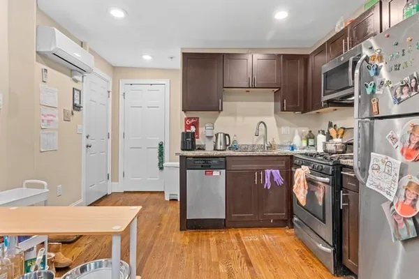 a kitchen with stainless steel appliances granite countertop a refrigerator and a stove top oven
