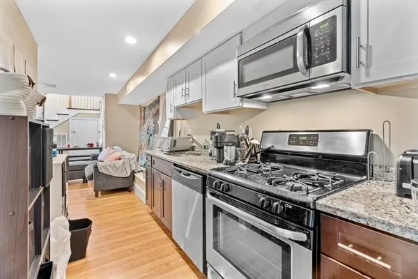 a kitchen with stainless steel appliances granite countertop a stove and a microwave