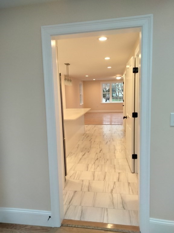 26 Woodleigh Road Dedham, MA 02026 - Photo 14 of 35 a view of a hallway with wooden floor and a living room