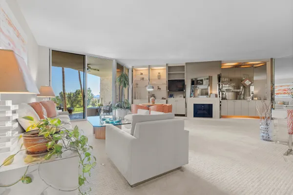 a living room with fireplace furniture and a floor to ceiling window