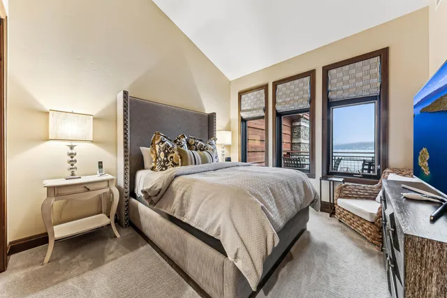 a spacious bedroom with a bed and a large window