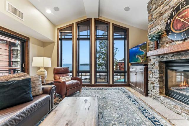 a living room with furniture a fireplace and large windows