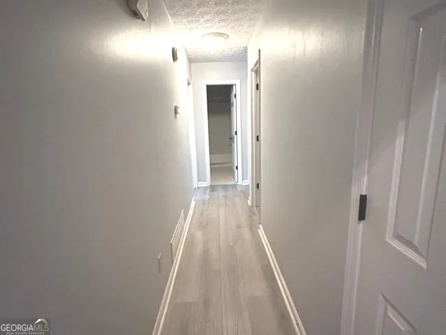 a view of a hallway with wooden floor