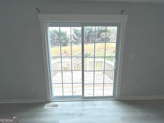 an empty room with wooden floor and balcony