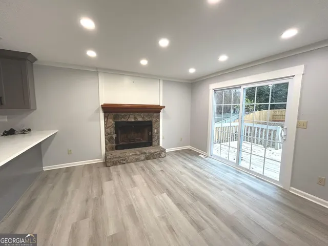 an empty room with wooden floor and a fireplace