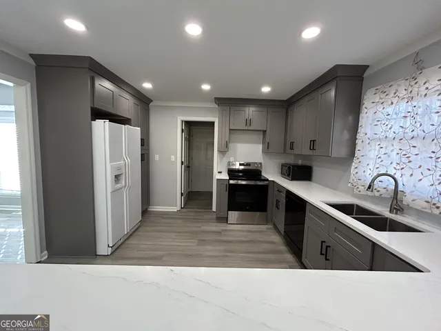 a kitchen with stainless steel appliances granite countertop a refrigerator and a sink