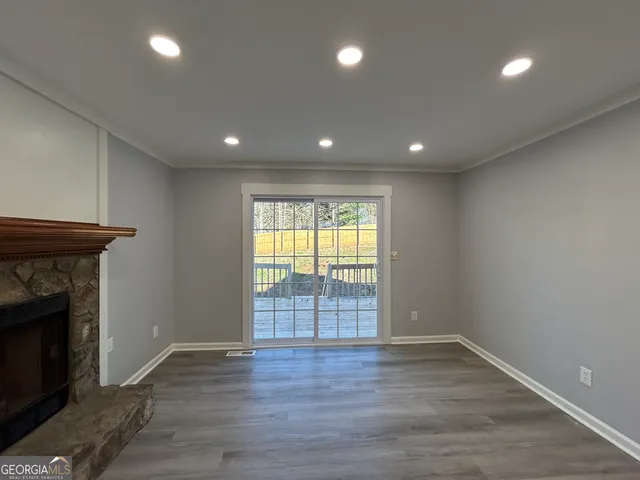 an empty room with wooden floor and a fireplace