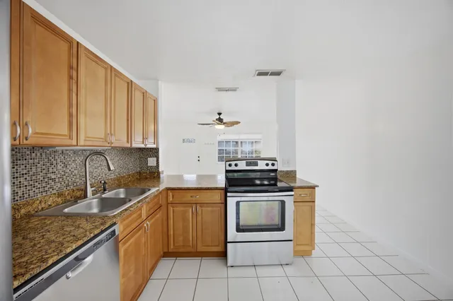a kitchen with a stove sink and cabinets
