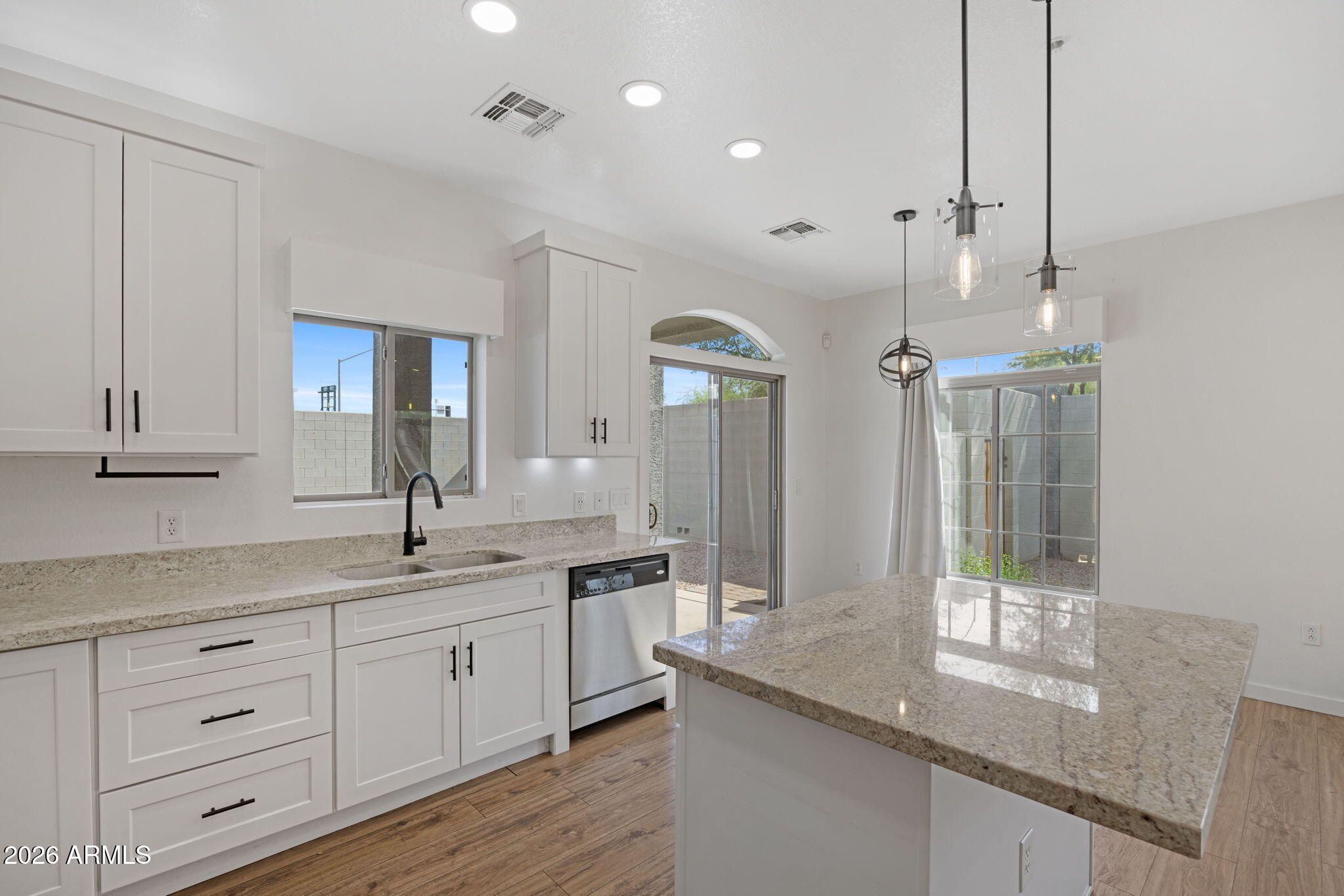 280 South Evergreen Road, Unit 1368 Tempe, AZ 85288 - Photo 15 of 42 a kitchen with granite countertop kitchen island white cabinets and white appliances