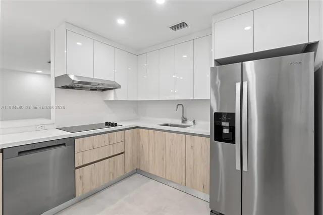 a kitchen with stainless steel appliances granite countertop a refrigerator and a sink