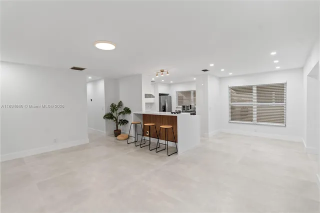 a dining room with furniture and a floor to ceiling window