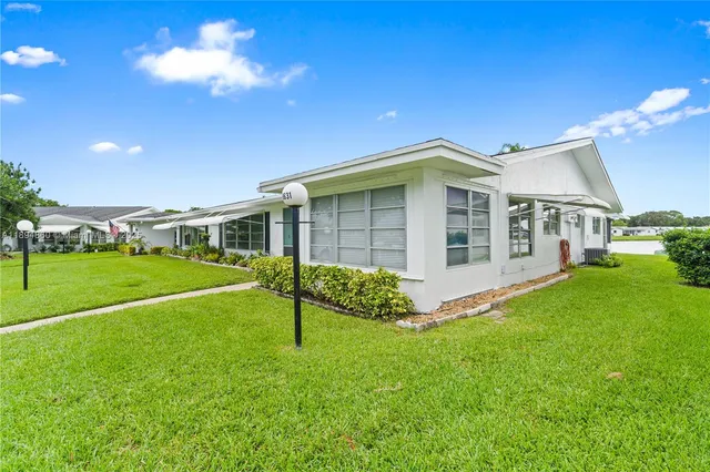 a view of an house with a swimming pool and a yard