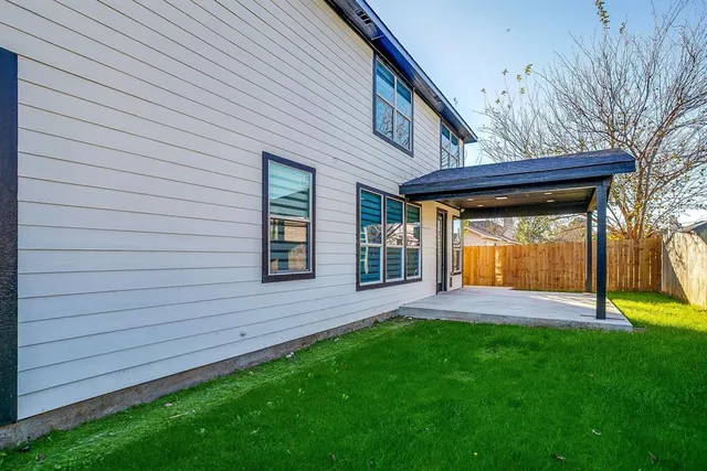 a backyard of a house with lots of green space and outdoor seating