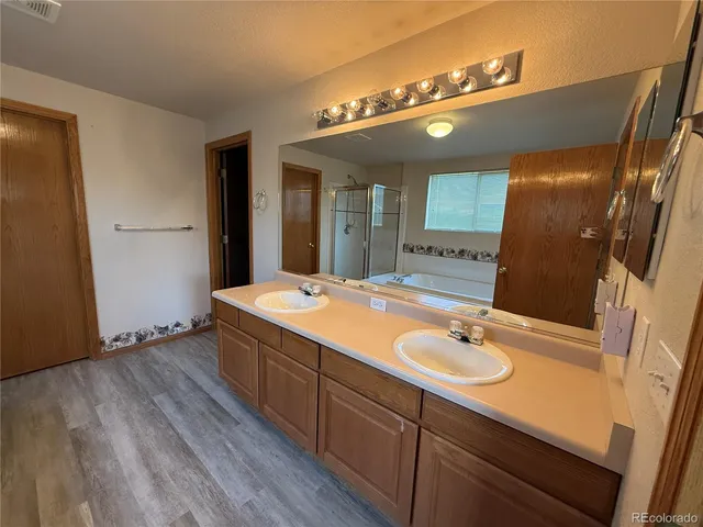 a spacious bathroom with a granite countertop sink a mirror and shower