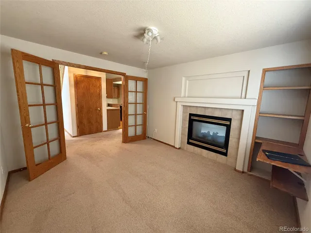 a view of an empty room with a fireplace and a window