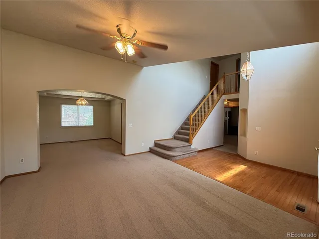 a view of an empty room with ceiling fan
