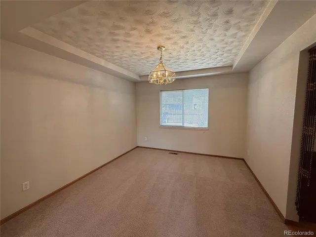 an empty room with windows and chandelier