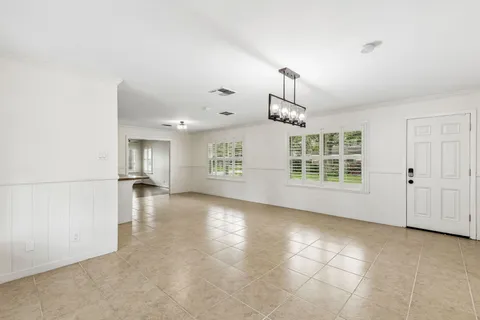 a large kitchen with kitchen island a sink a stove a refrigerator and white cabinets