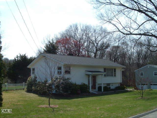 a front view of house with garden and trees