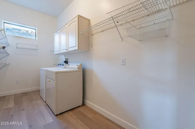 a utility room with cabinets washer and dryer