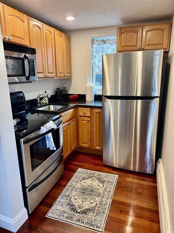 40 Chappie Street, Unit 1 Boston, MA 02129 - Photo 2 of 10 a kitchen with stainless steel appliances granite countertop a refrigerator stove top oven and sink