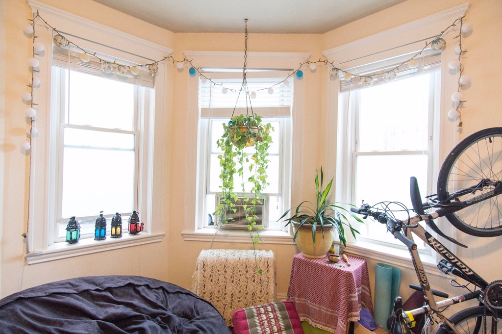 233 Kelton Street, Unit 1 Boston, MA 02134 - Photo 2 of 11 a bedroom with furniture and a large window