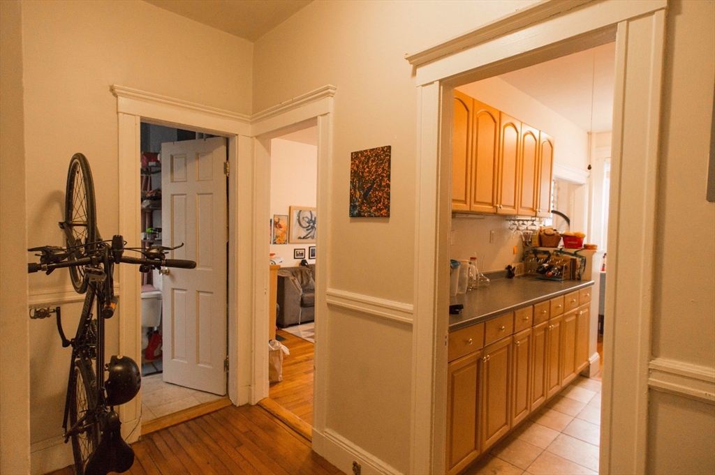 233 Kelton Street, Unit 1 Boston, MA 02134 - Photo 7 of 11 a view of a hallway with wooden floor and a bathroom