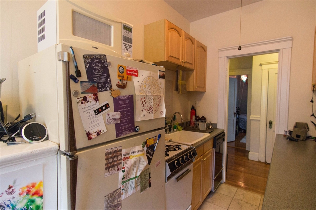 233 Kelton Street, Unit 1 Boston, MA 02134 - Photo 8 of 11 a kitchen with stainless steel appliances granite countertop a stove and a sink