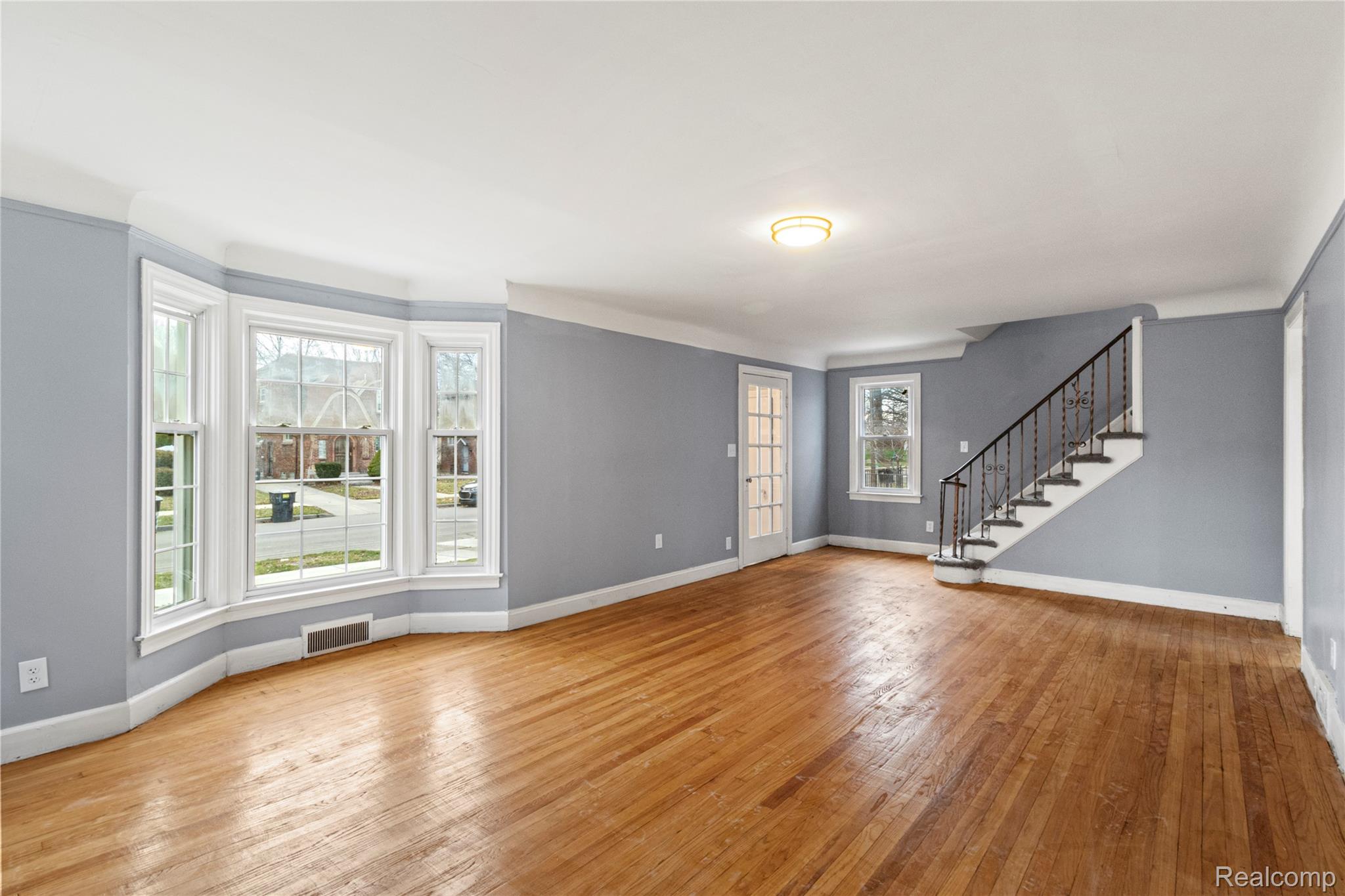 4834 Devonshire Road Detroit, MI 48224 - Photo 9 of 22 Unfurnished living room featuring stairs and light wood-type flooring