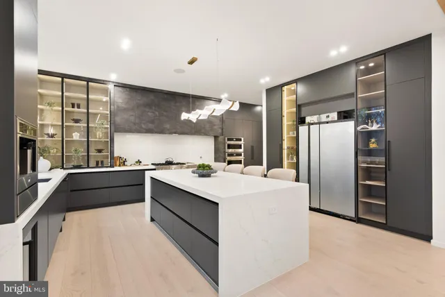 a large white kitchen with a refrigerator a sink stainless steel appliances and cabinets